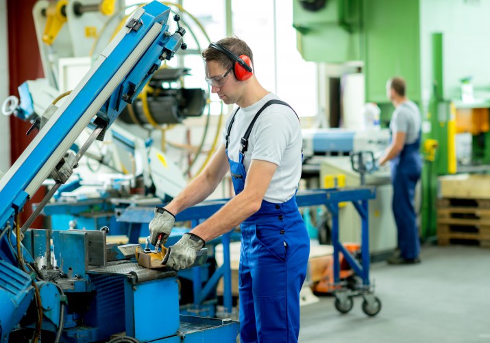 35663926 - worker in protective clothing in factory using machine